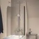 Duschsystem von Ideal Standard mit Wandmontage, verchromter Armatur, Regenbrause und Handbrause, angebracht über einer Badewanne an einer hellen Wand.